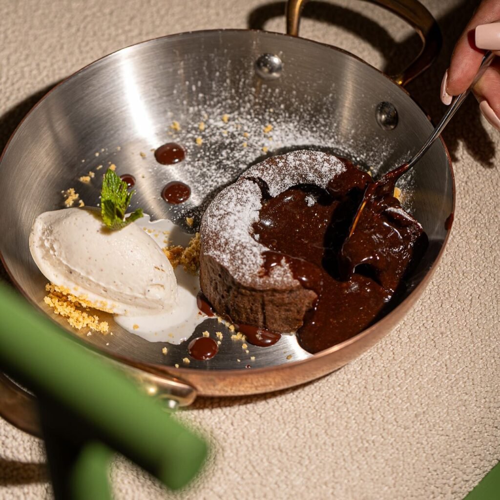 Fondant au chocolat maison servi avec glace vanille et coulis, photographié au restaurant Lily Billy à Marrakech — une touche sucrée emblématique des desserts maison.