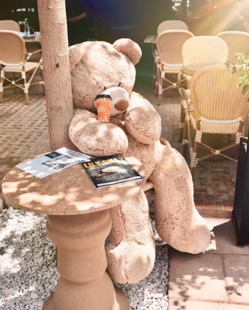Ours en peluche géant avec gobelet Lily Billy sur terrasse restaurant - Le Meilleur Burger à Marrakech