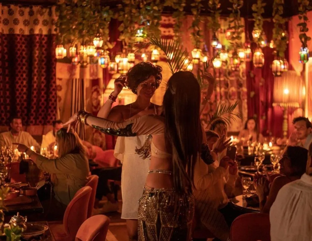 Spectacle de danse orientale dans un restaurant marocain animé à Marrakech le soir