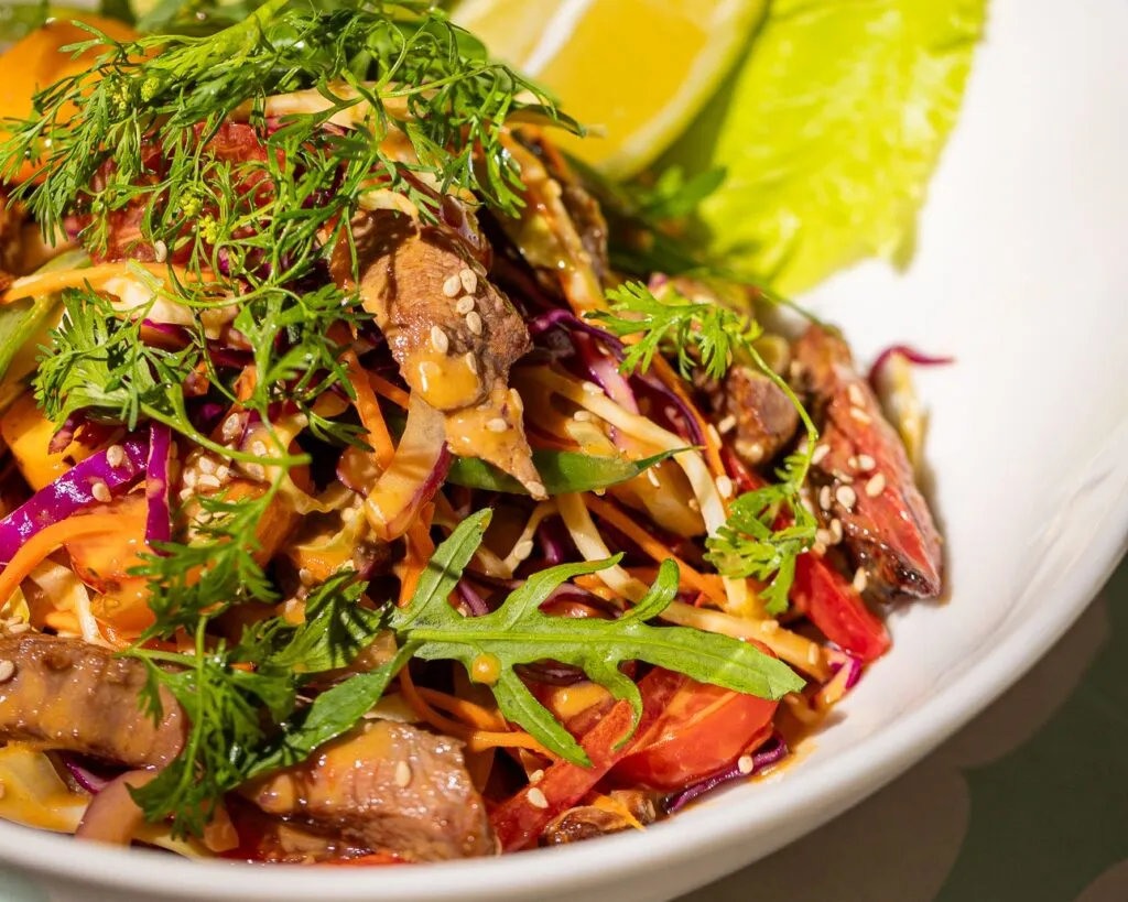 Gros plan d'une salade thaï au bœuf, crudités et graines de sésame, Lily Billy Marrakech