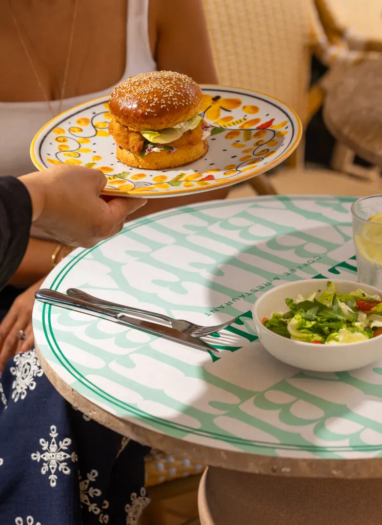 Burger croustillant au sésame servi avec salade verte, présenté en terrasse chez Lily Billy Marrakech