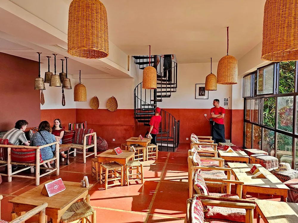 Salle d'un café marocain à Marrakech avec escalier en colimaçon et suspensions en osier