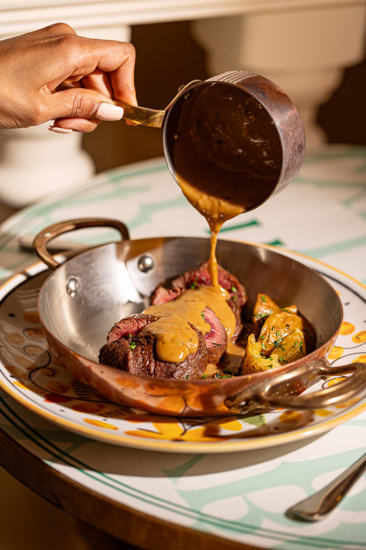 Pepper sauce poured over a sliced beef steak with roasted potatoes at a top Marrakech restaurant