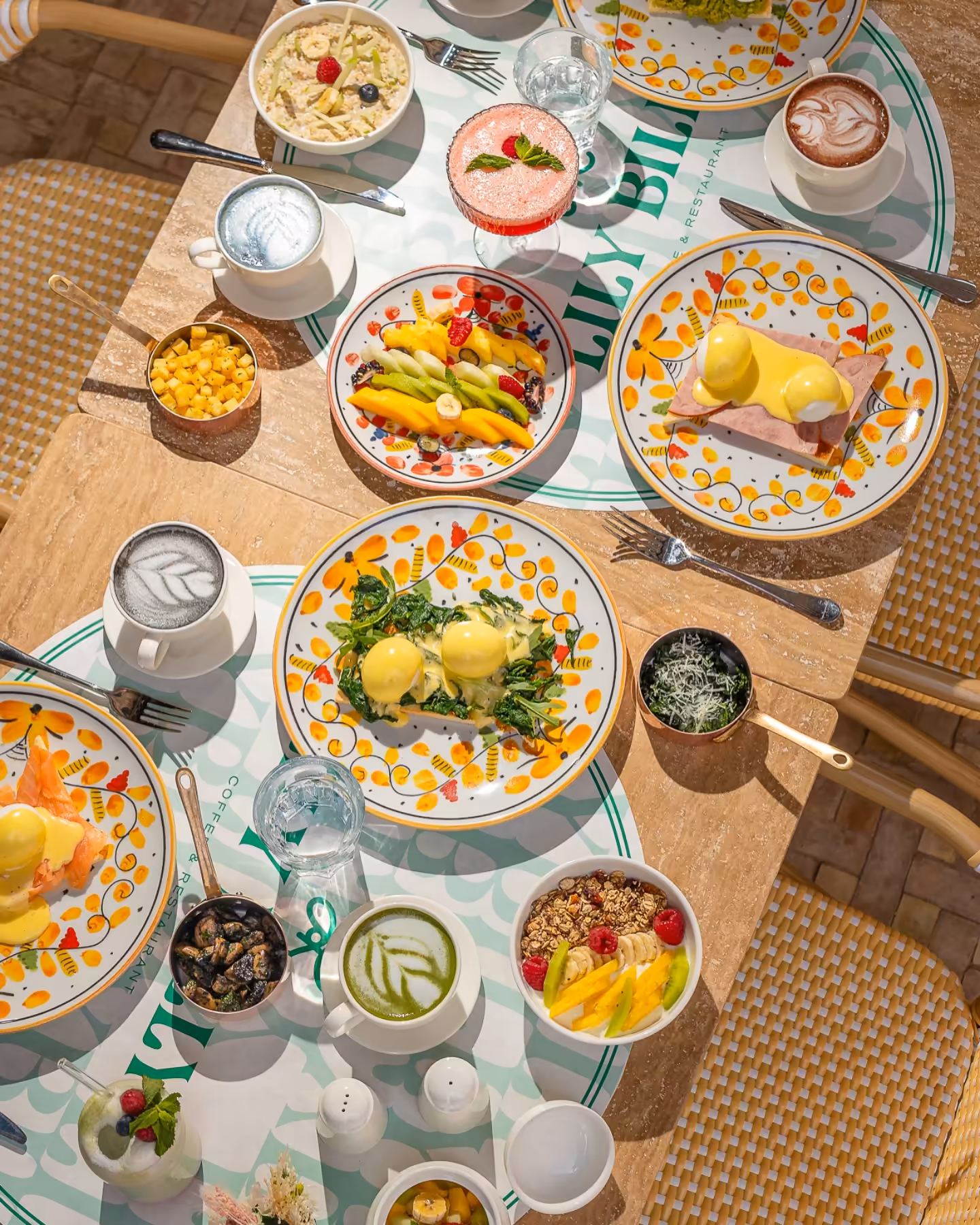 Overhead brunch spread with Eggs Benedict, fruit and lattes, best brunch in Marrakech