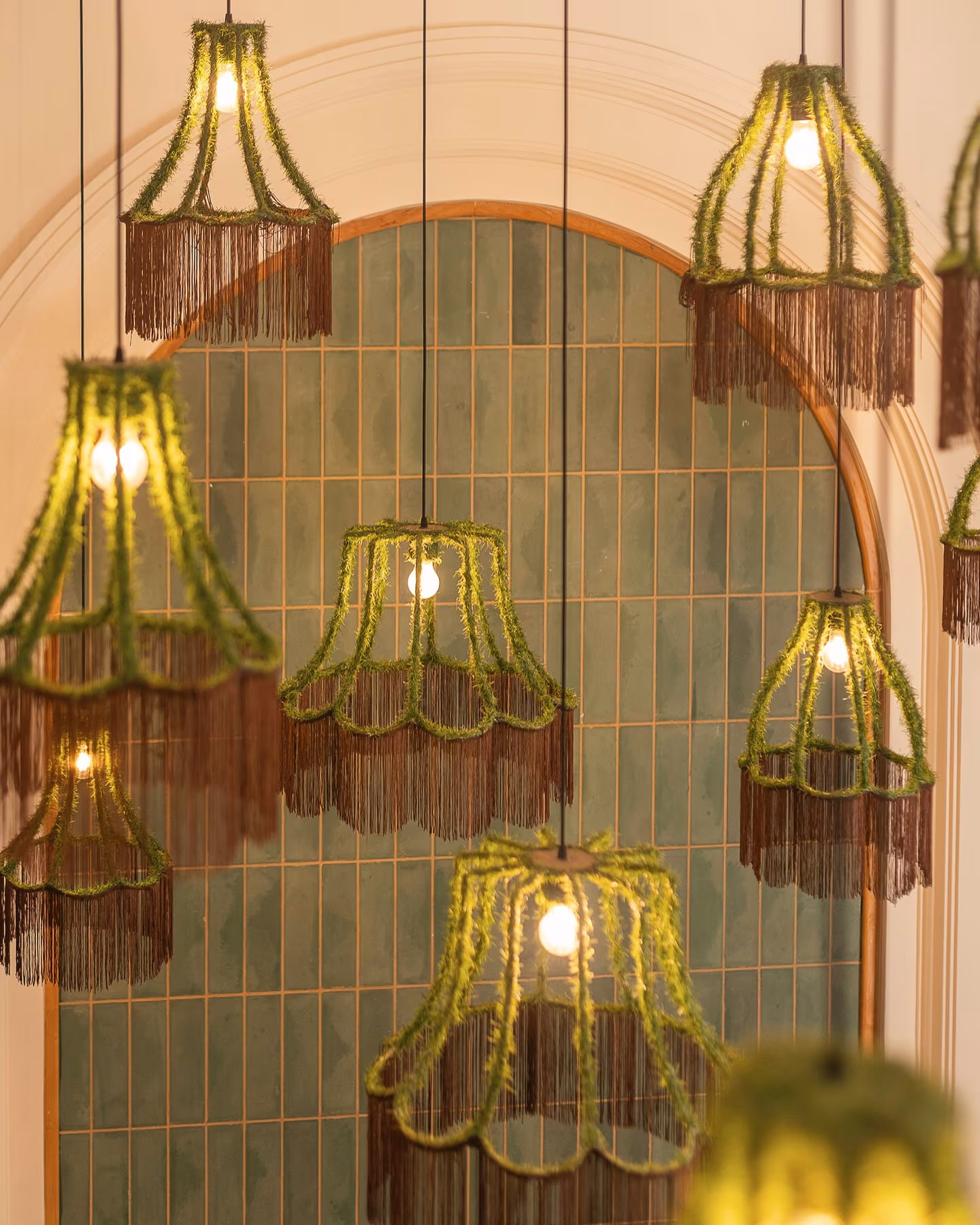 Green fringed pendant lights over a tiled arch inside Lily Billy, a breakfast spot in Gueliz, Marrakech