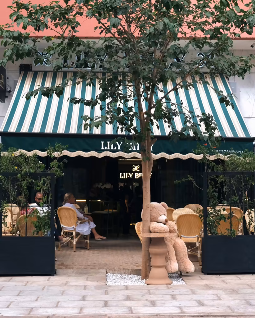 Lily Billy cafe storefront with green striped awning and terrace in Gueliz, Marrakech