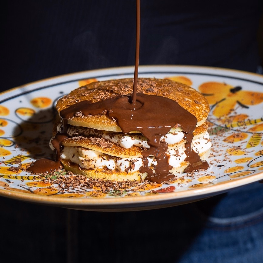 Mascarpone pancake stack with chocolate sauce poured over, brunch in Marrakech